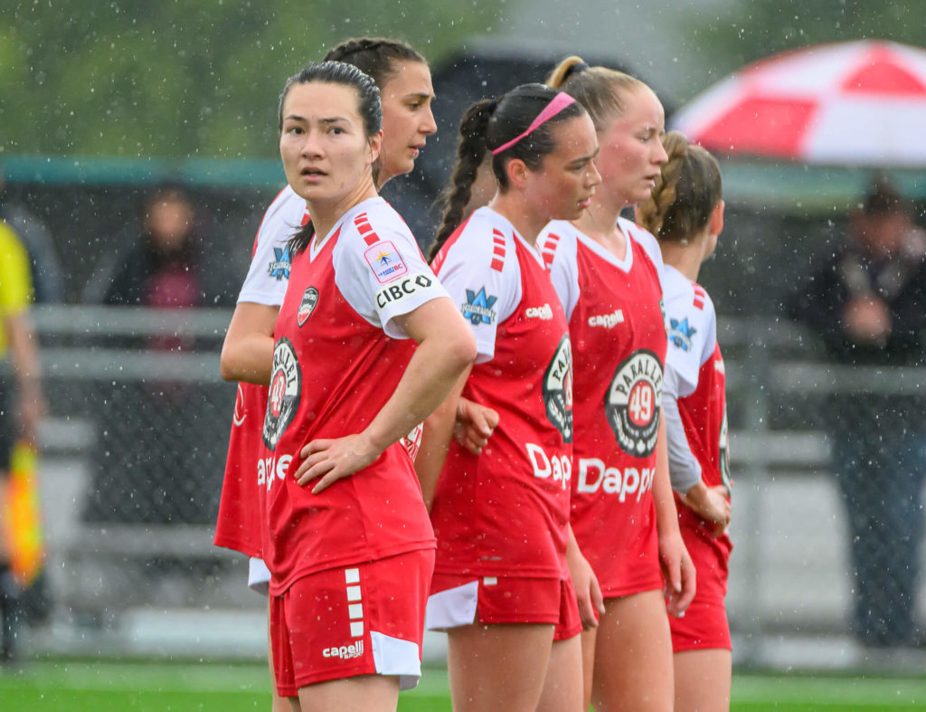 Katie Bishop looks to the camera as the rest of the line sets up the wall
